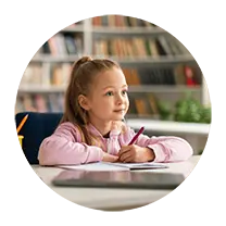 Little girl at her desk in class paying attention and absorbing information